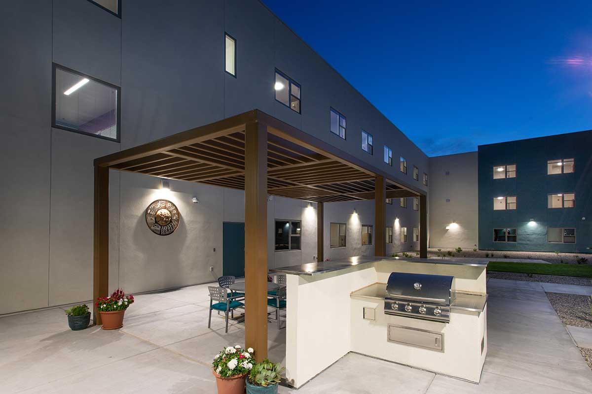 Back patio with outdoor spaces including grill and table at San Juan College Student Housing.